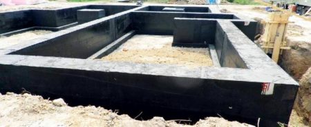 Peinture de l'imperméabilisation d'une fondation monolithique dans un bâtiment sans sous-sol