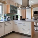 Grande cuisine vitrée avec des meubles blancs