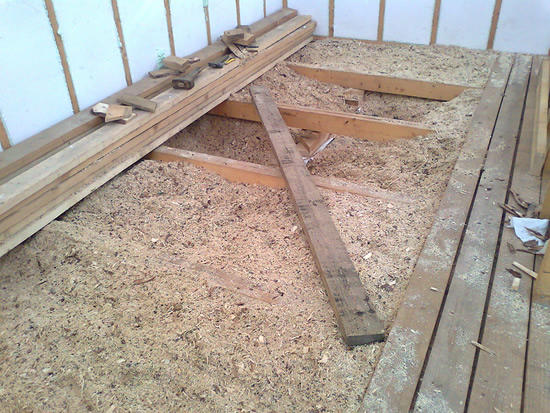 Avant de commencer à isoler le plafond avec de la sciure de bois, il est nécessaire de couvrir toute la surface du plafond avec du carton, puis de répartir la composition et de la tasser