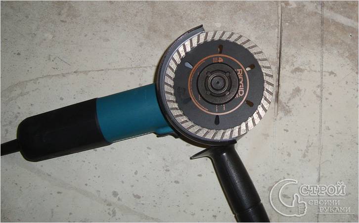 Scier le cadre avec une meuleuse sur du béton