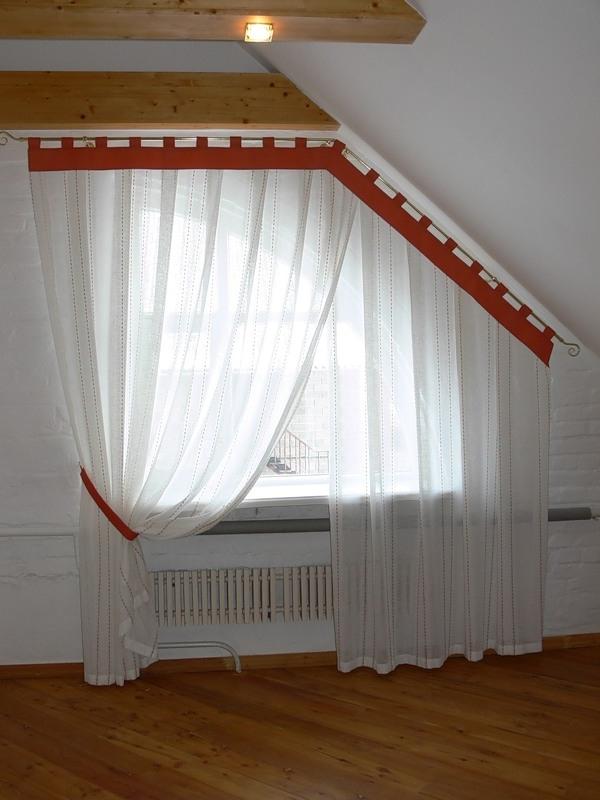 Rideaux sur une corniche ronde sur une fenêtre biseautée