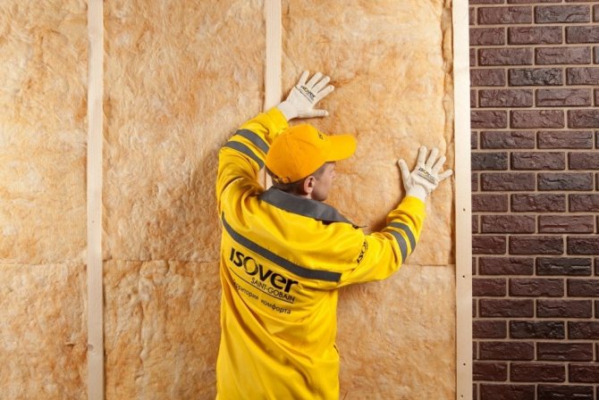 Pose de laine minérale sur une latte d'une barre