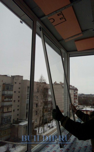 Installation de portes coulissantes en aluminium sur le balcon.